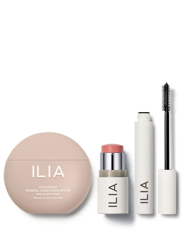 Set of ILIA makeup products including a compact mineral sunscreen SPF 50, multi blush and lip stick, and mascara on a white background.