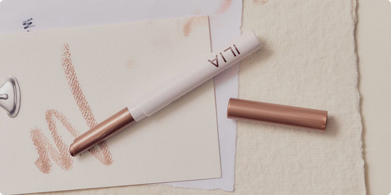 Eye Stylus eyeshadow with rose gold accents on a textured surface